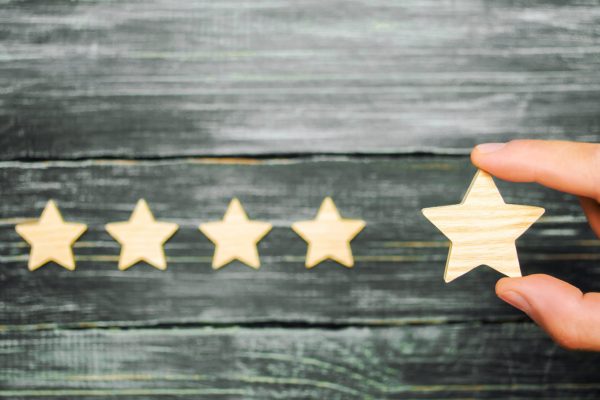 The businessman's hand holds the fifth star. A new star, achievement.The concept of the rating of hotels and restaurants, the evaluation of critics and visitors. Quality level, good service.